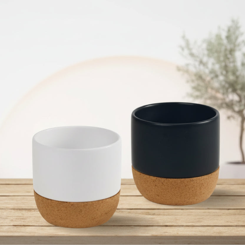 Two ceramic cups with wooden bases on a wooden surface.